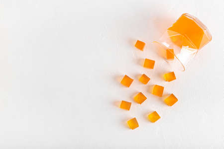 Glass with tasty jelly cubes on white backgroundの写真素材