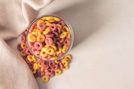 Glass with crunchy corn flakes rings on white backgroundの写真素材
