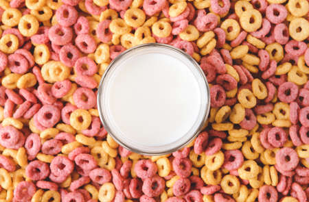 Glass of milk with crunchy corn flakes ringsの写真素材
