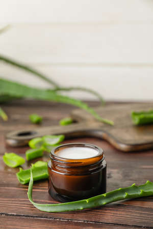 Jar with natural cream and aloe pieces on wooden backgroundの写真素材