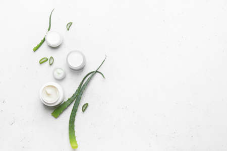Jars with natural cream and aloe pieces on light backgroundの写真素材