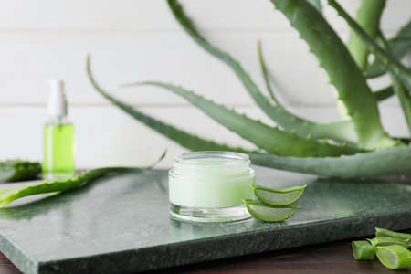 Jar with natural cream and aloe pieces on marble backgroundの写真素材