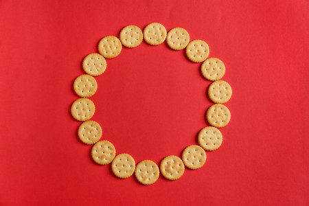 Frame made of tasty crackers on color backgroundの写真素材
