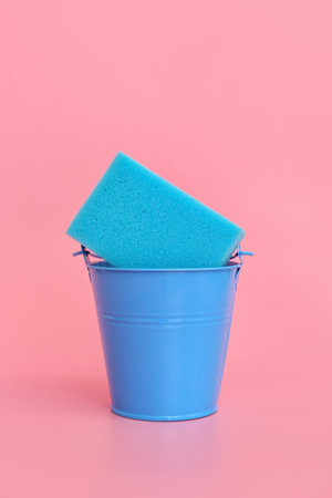 Bucket with sponge on color backgroundの写真素材