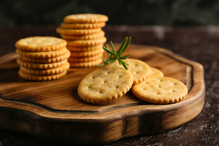 Board with tasty crackers on dark backgroundの写真素材