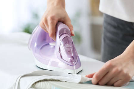 Woman ironing clothes at home, closeupの写真素材