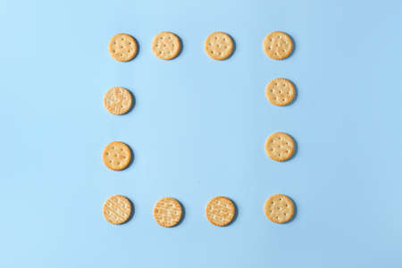Frame made of tasty crackers on color backgroundの写真素材