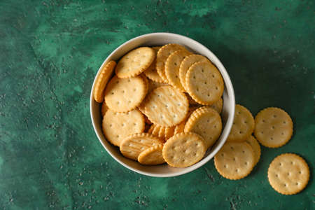 Bowl with tasty crackers on color backgroundの写真素材