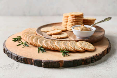 Plate with tasty crackers and peanut butter on light backgroundの写真素材