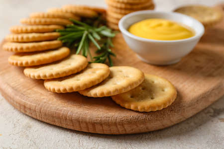 Board with tasty crackers on light backgroundの写真素材