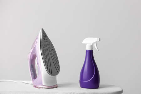 Electric iron and board on light backgroundの写真素材