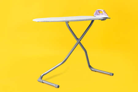 Board with electric iron on color backgroundの写真素材