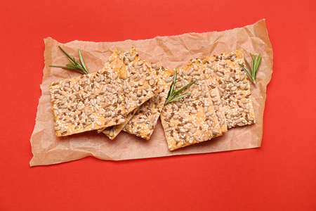 Tasty crackers with seeds on color background