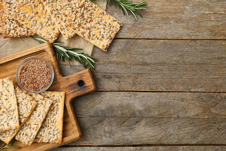 Tasty crackers with seeds on wooden background