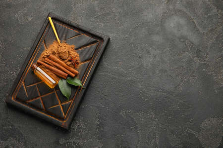 Cinnamon oil, sticks and powder on gray backgroundの写真素材
