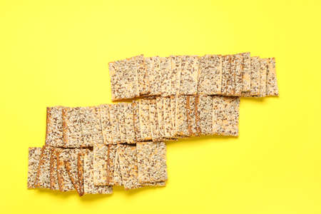Tasty crackers with seeds on color backgroundの写真素材