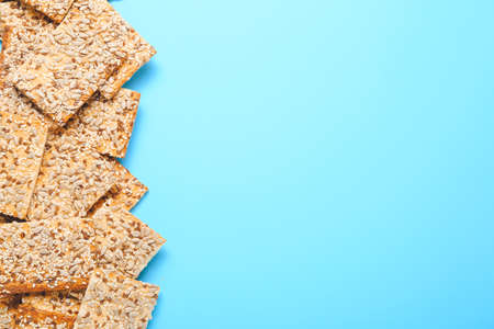Tasty crackers with seeds on color backgroundの写真素材