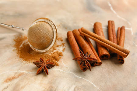 Tea strainer and aromatic cinnamon on color backgroundの写真素材
