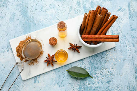 Composition with cinnamon oil, sticks and powder on color backgroundの写真素材
