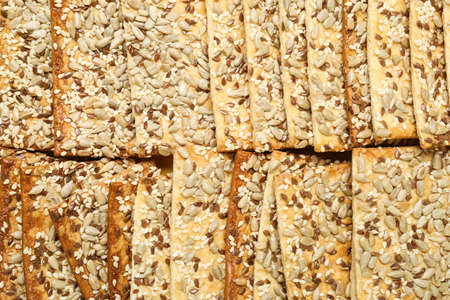 Tasty crackers with seeds as backgroundの写真素材