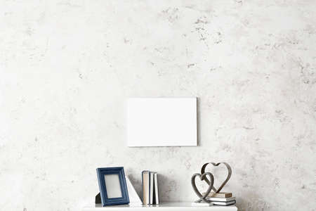 Photo frame, books and decor on mantelpiece