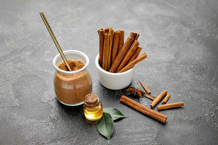 Cinnamon oil, sticks and powder on gray backgroundの写真素材