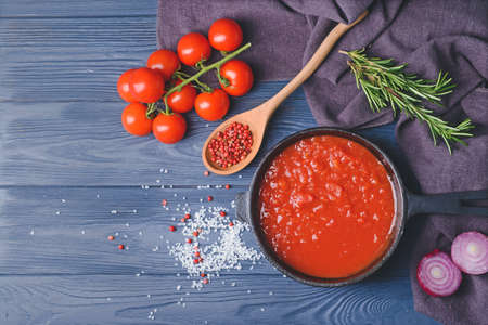 Frying pan with organic tomato sauce on wooden backgroundの写真素材