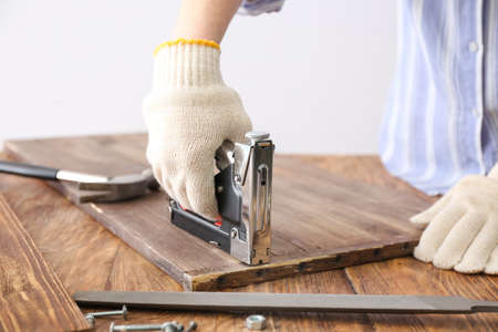 Female hand with construction stapler on table closeupの写真素材