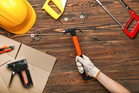 Female hand with tools on wooden background