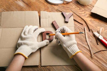 Female hands with pencil and word DIY on wooden backgroundの写真素材