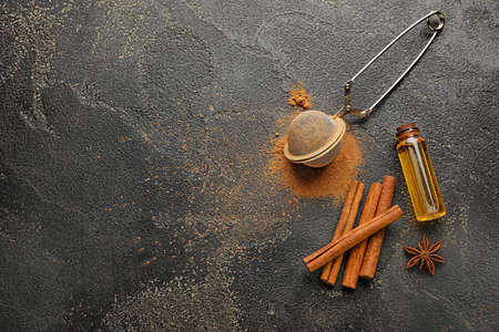 Cinnamon oil, sticks, powder and strainer on gray backgroundの写真素材