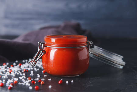 Jar with organic tomato sauce on dark backgroundの写真素材