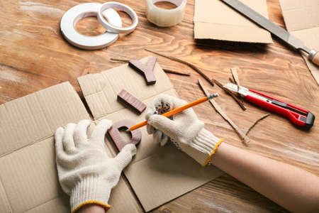 Female hands with pencil and word DIY on wooden backgroundの写真素材