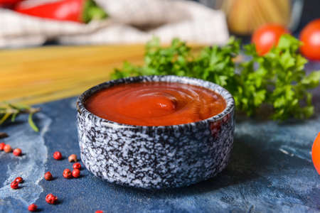 Bowl with organic tomato sauce on color backgroundの写真素材