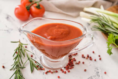 Gravy boat with organic tomato sauce on white backgroundの写真素材