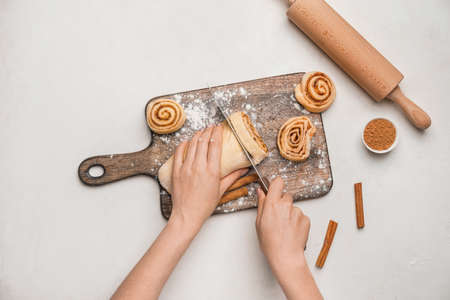Woman preparing tasty cinnamon rolls on table, top viewの写真素材