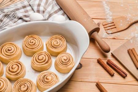 Baking dish with uncooked cinnamon rolls on wooden backgroundの写真素材