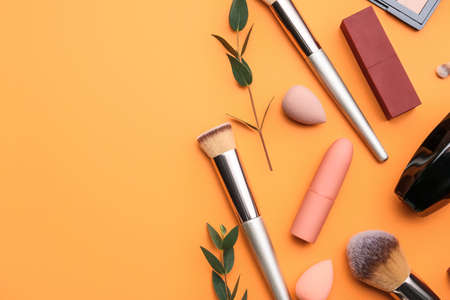 Decorative cosmetics and makeup brushes on color backgroundの写真素材