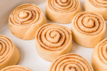 Baking dish with uncooked cinnamon rolls closeup