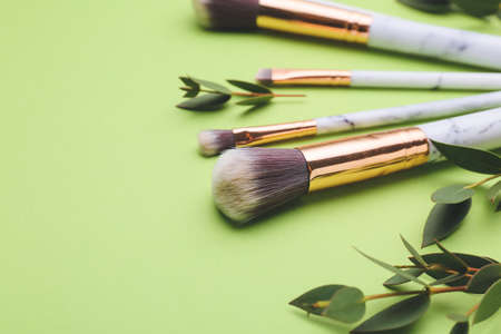 Composition with makeup brushes on color background