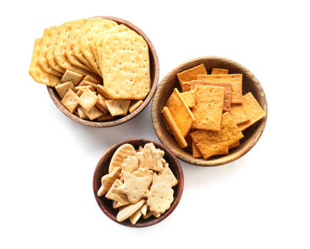 Bowls with tasty different crackers on white backgroundの写真素材