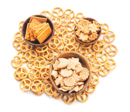 Bowls with tasty different crackers on white backgroundの写真素材