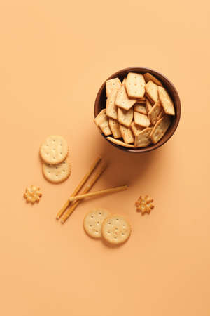 Bowl with tasty different crackers on color backgroundの写真素材