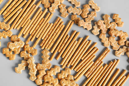 Tasty different crackers on light background
