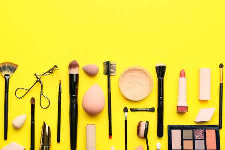 Decorative cosmetics and makeup brushes on color backgroundの写真素材