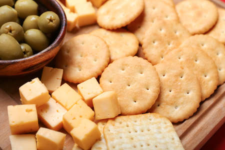 Board with tasty crackers, cheese and olives, closeupの写真素材