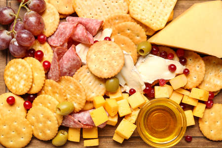 Board with tasty crackers with cheese and snacks, closeupの写真素材