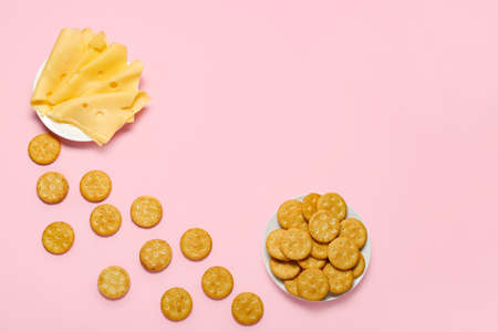 Plates with tasty crackers and cheese on color backgroundの写真素材