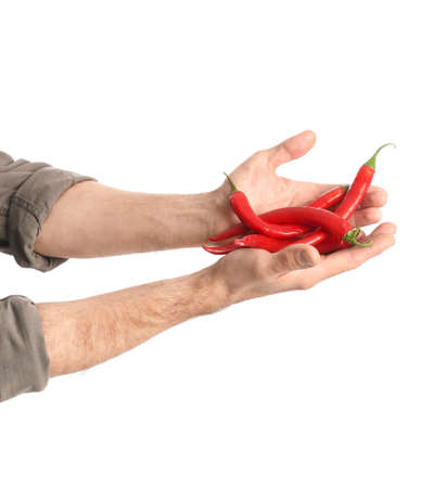 Male hands and chili peppers on white backgroundの写真素材