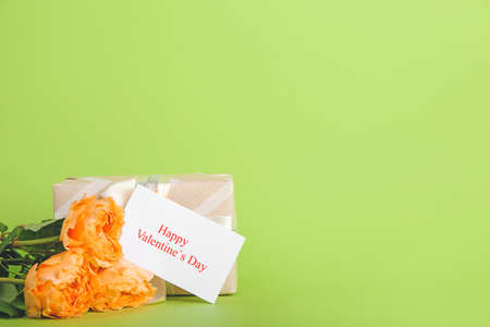 Gift, rose flowers and greeting card for Valentines Day celebration on color backgroundの写真素材